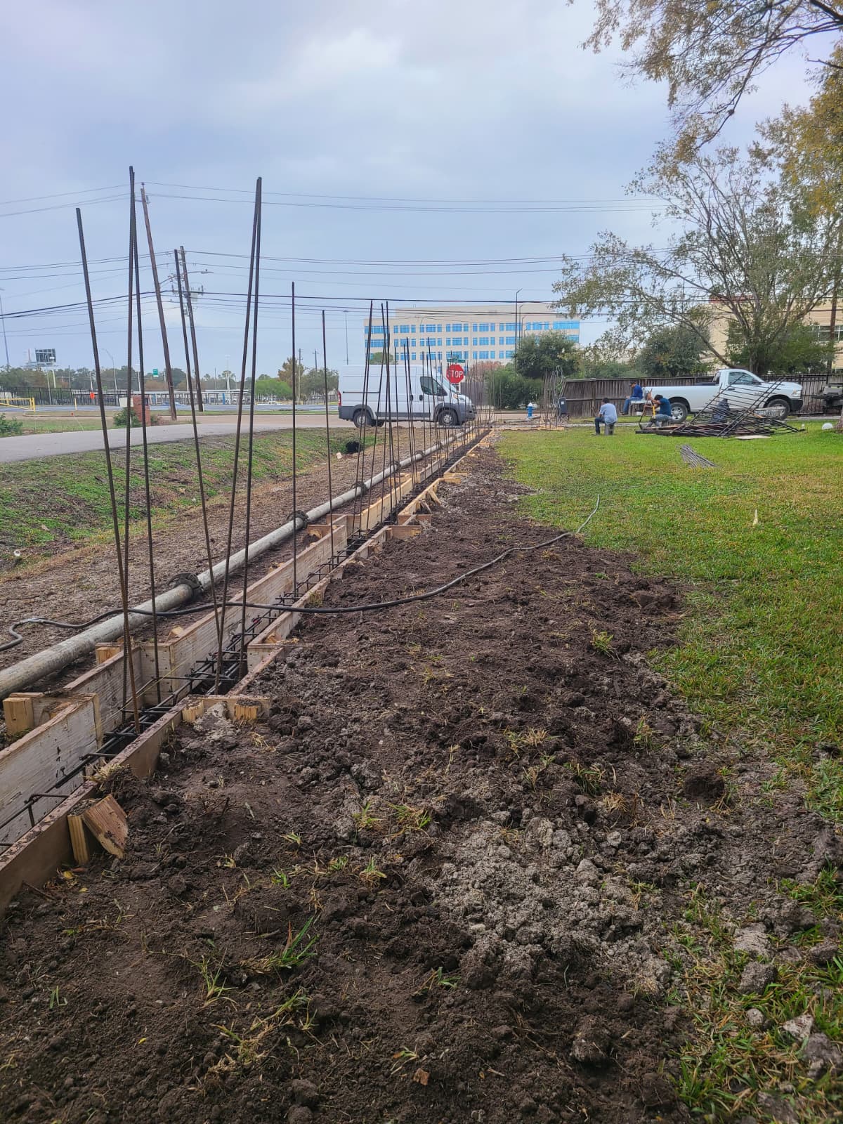Intersection of footing and pier with tied rebar for perimeter fence