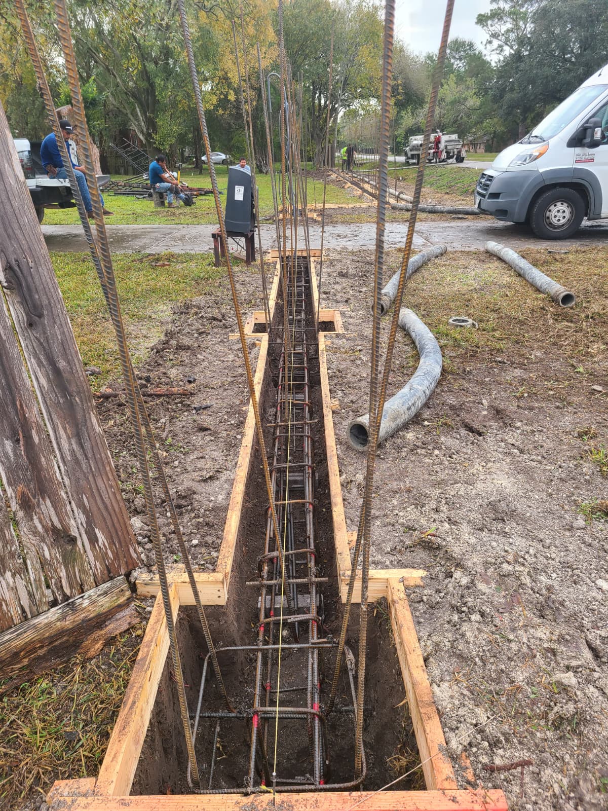 Rebar cage installed along footing trench for perimeter fence